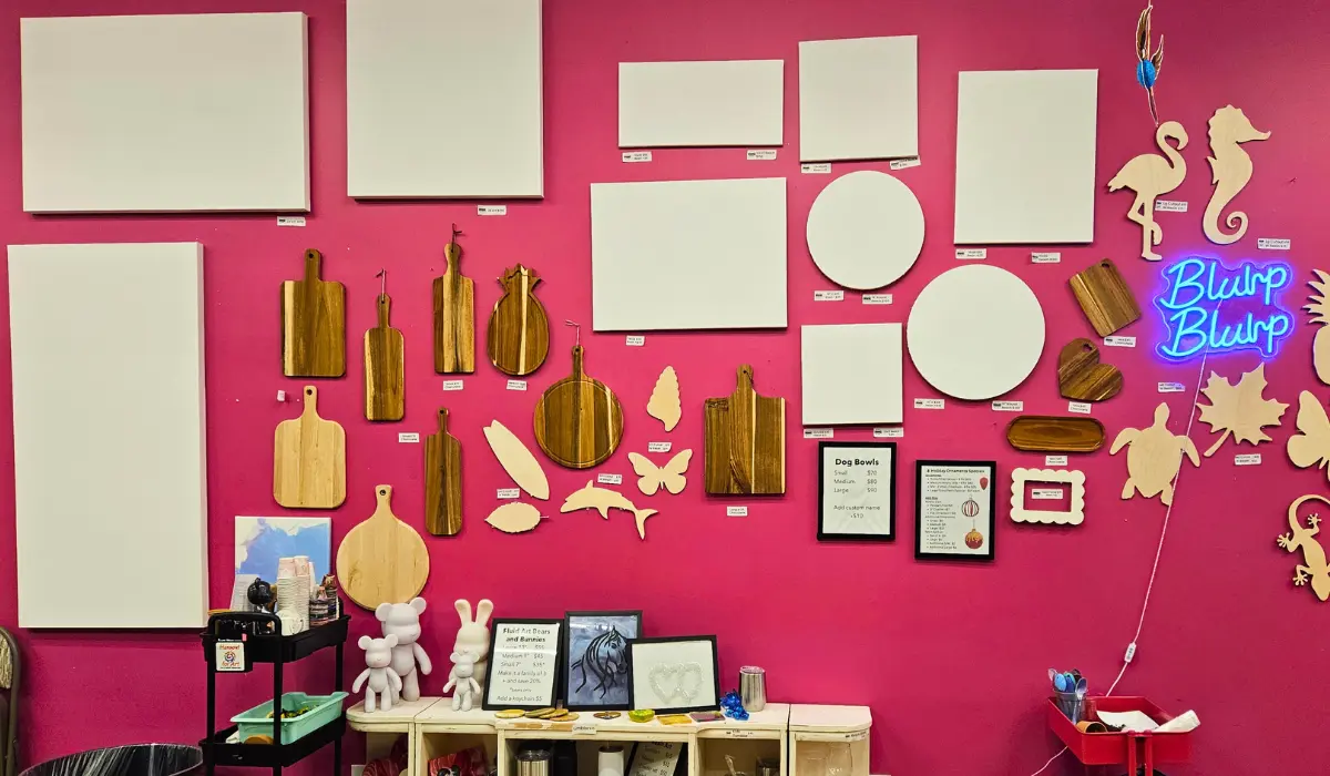 Pink wall display of blank canvases and wooden surfaces at Hangout for Art studio showroom