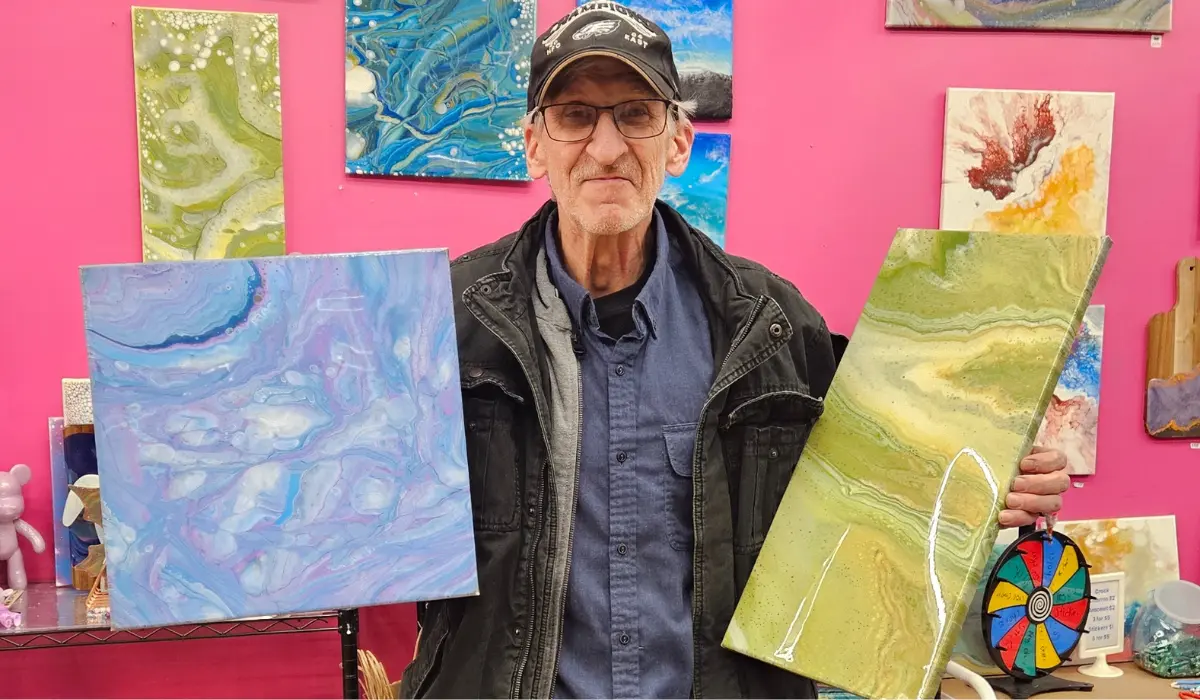 Man holding blue galaxy and green resin art pieces at Hangout for Art studio in Allentown