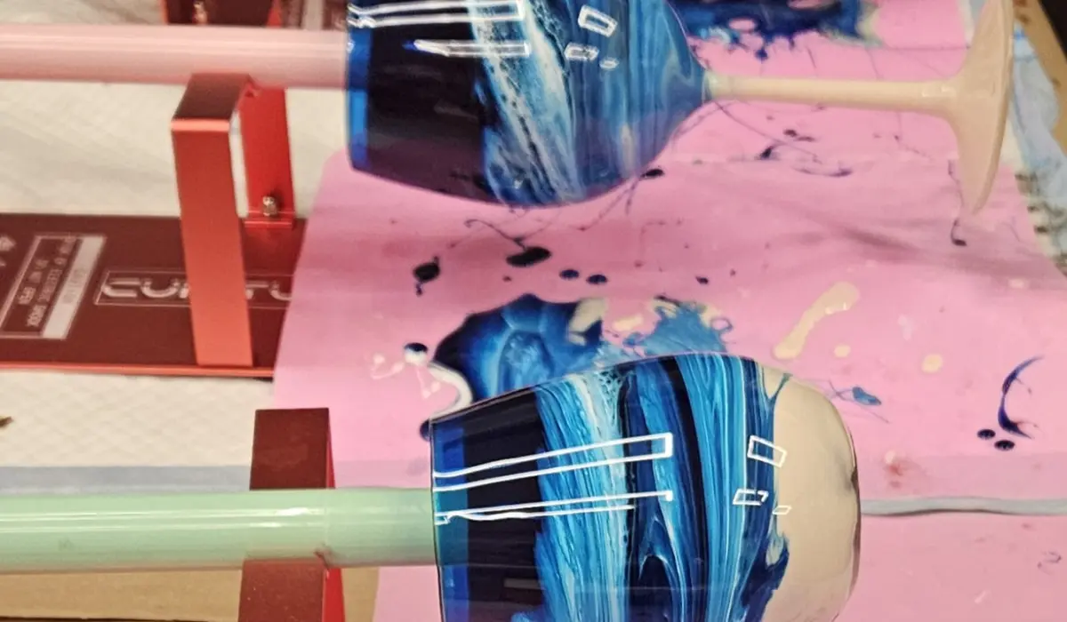 Blue swirled resin wine glass on spinner with pink canvas and supplies at Hangout for Art