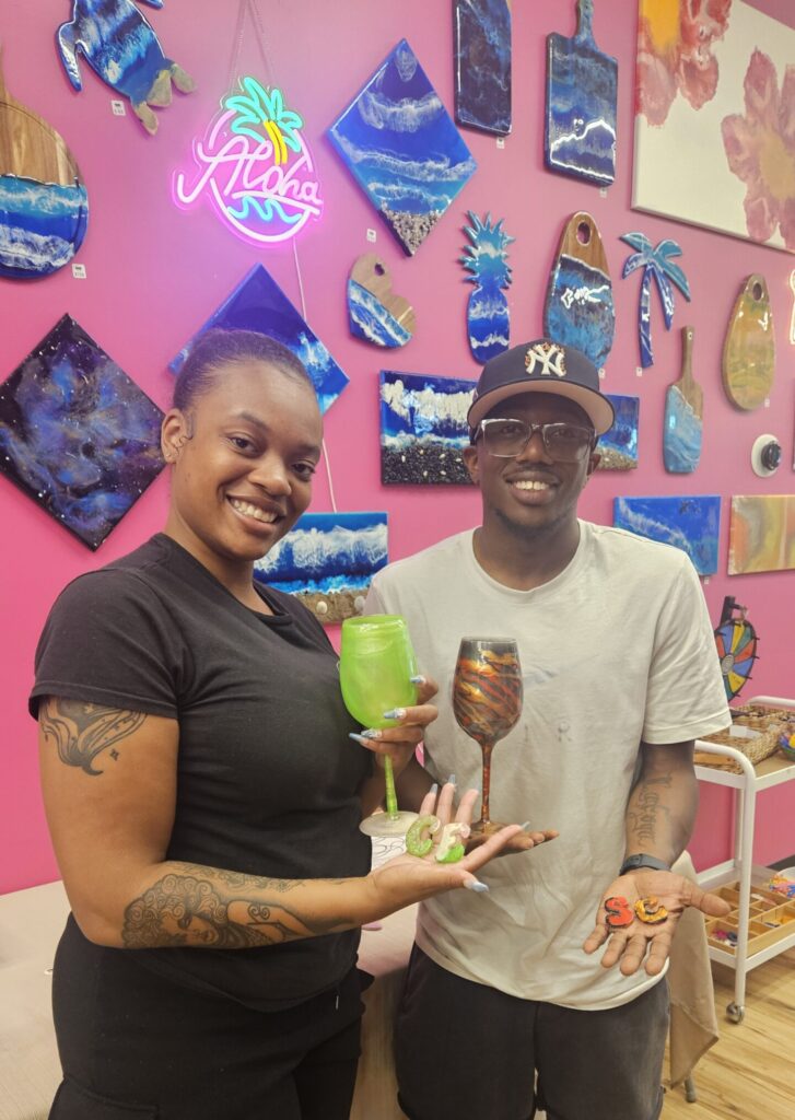 Guest laughing, holding their finished resin tumbler at Hangout for Art