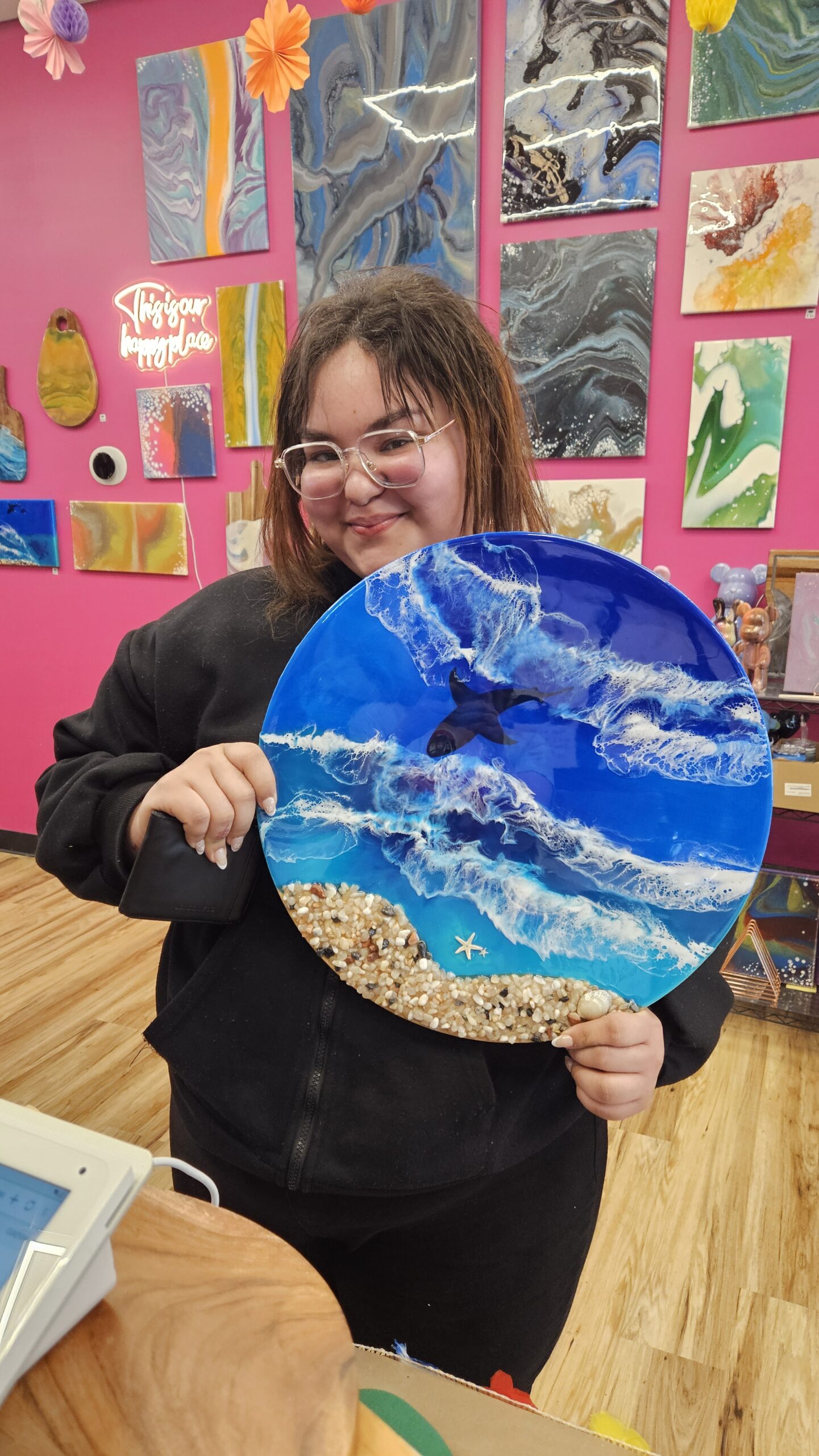 Guest proudly holding their finished resin beach scene at Hangout for Art
